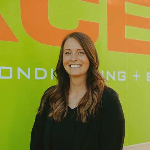 Smiling ServiceXEL team member standing in front of company-branded vehicle